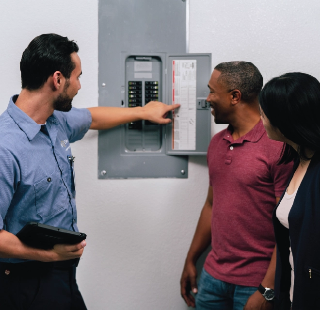 Mr electric technician showing a panel to customers.