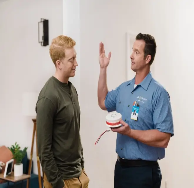 A Mr. Electric discussing electrical safety with customer in Bangor, MI.