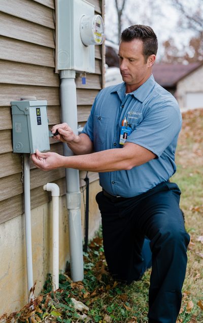 Electrician works on outdoor electrical job.
