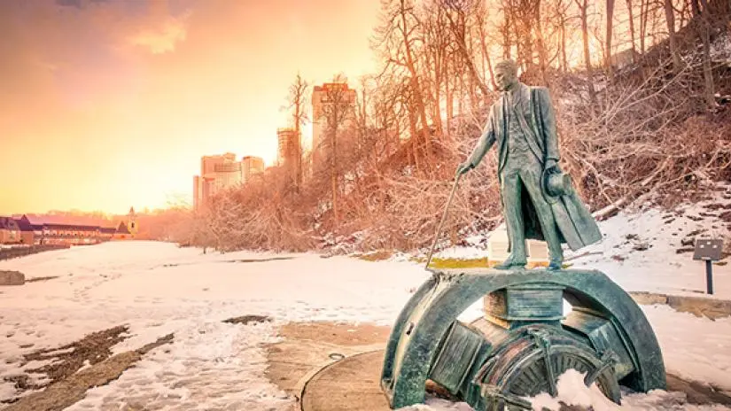 Statue of famous electricity pioneer in a snowy city.