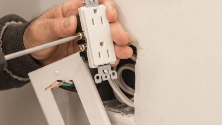 Person preparing to install an electric wall outlet.