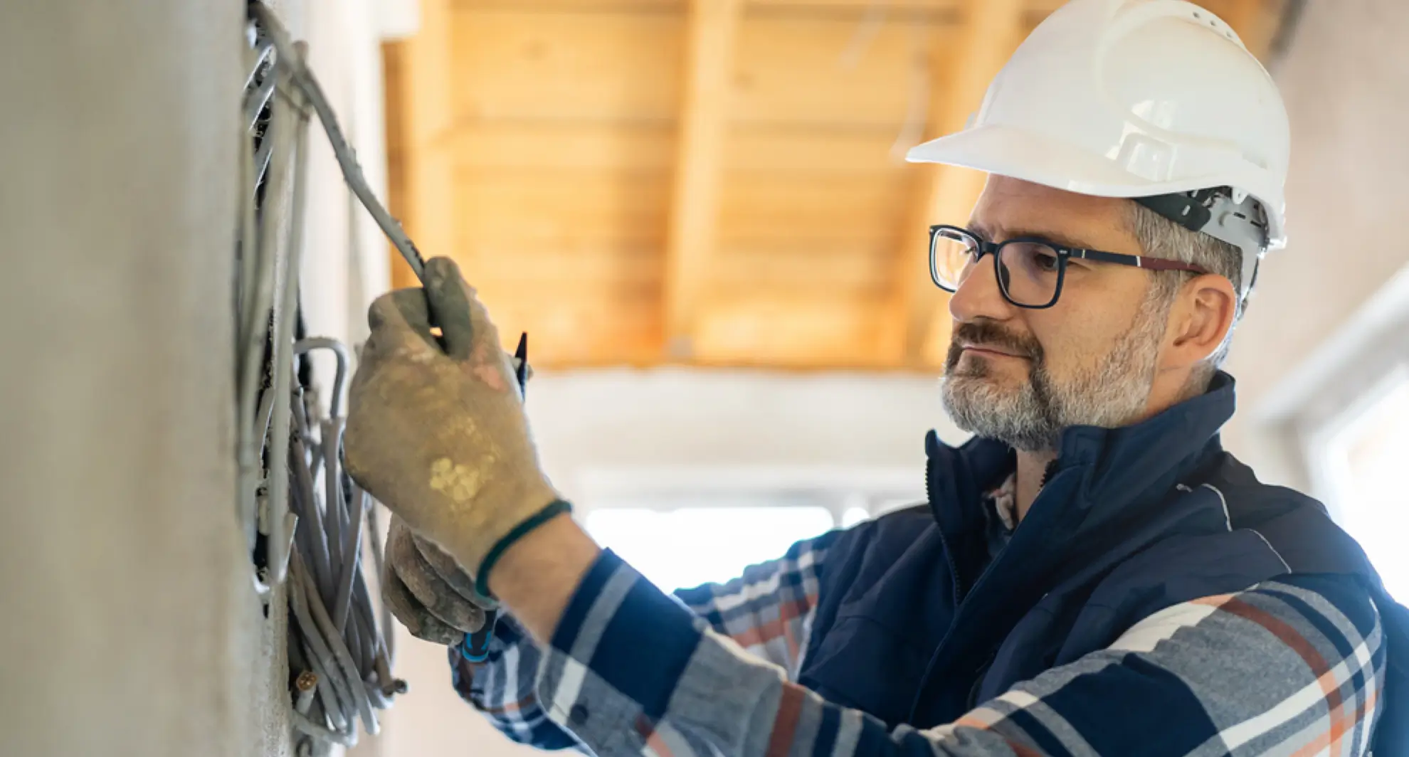 Electrician checking wires inside wall for buzzing sound