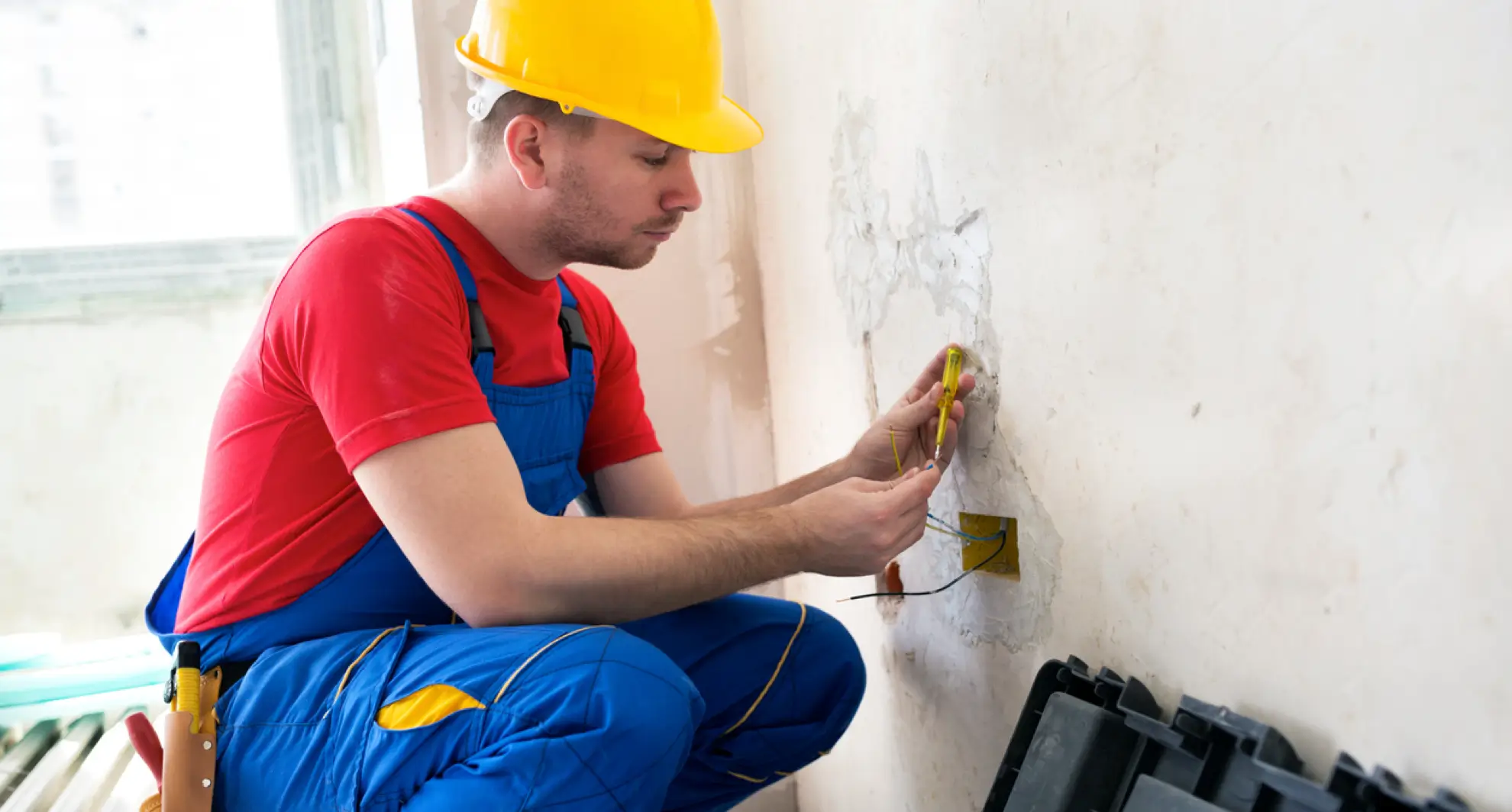 Service professional testing electrical wires for humming noise in wall
